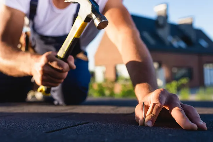 Roofer inspecting roof shingles in Connecticut